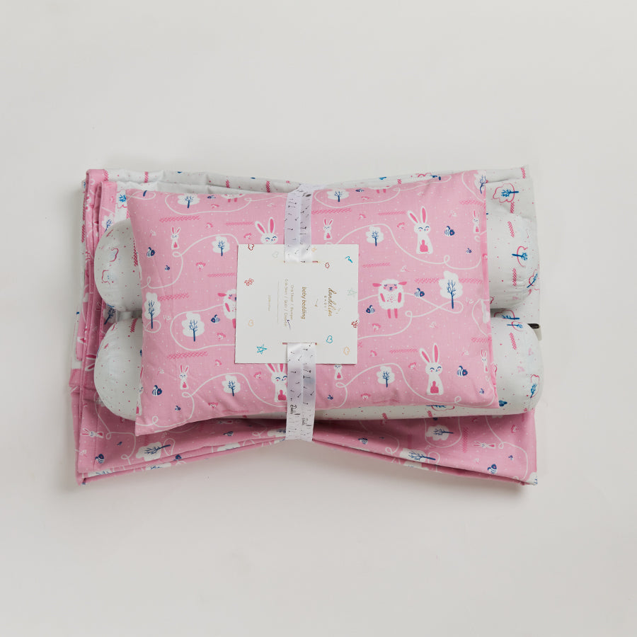 reversible coverlet, made of double-layered breathable cotton, a baby pillow and two bolsters with washable covers.